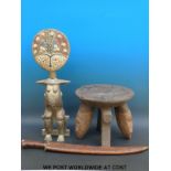 A carved African stool with masked legs together with a fertility figure inset with cowrie shells