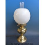 A brass oil lamp converted for modern electric use complete with glass shade