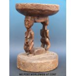 An African figural tribal stool with female and male figures supporting the seat on their heads