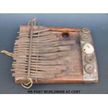 African tribal Lamellophone or Kalimba (thumb piano) with 19 bent metal notes and five bottle tops