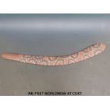 An Aboriginal wooden boomerang with painted decoration of dark loops surrounded by white spots on