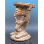 An African tribal stool with a kneeling female figure supporting the seat on her head (35cm tall)