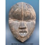 An African tribal Dan mask with metal teeth and sectioned forehead (length 26cm)
