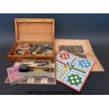 A boxed games compendium including carved wooden chess and draught pieces,