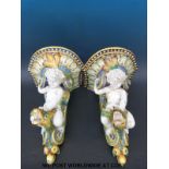 A pair of large majolica wall brackets in the form of putti riding a sea serpent,