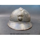 A French WWI military helmet with RB and flaming grenade to front, of four piece construction (comb,