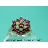 A 9ct gold ring set with opals and rubies in a cluster (size O)