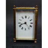 An early to mid 20thC brass carriage clock with white enamelled dial, Roman numerals,