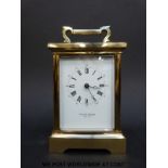 Taylor and Bligh brass carriage clock, in coriche style case with white enamel dial,