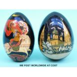 Two Russian lacquer eggs, one decorated with a Russian palace, the other a figure on horseback,