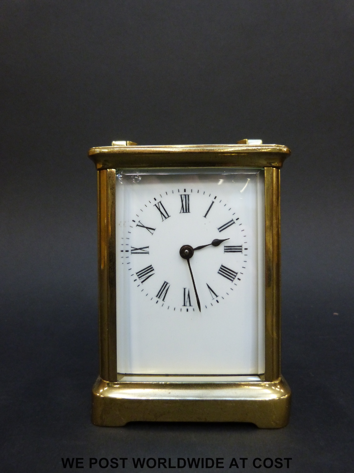 A brass carriage clock in corniche style case, with white enamelled dial,