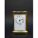 A brass carriage clock in corniche style case, with white enamelled dial,