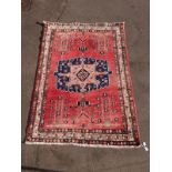 A wine ground Turkoman rug with central blue and pink gul (L228xW159cm)