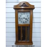 A c1910 light oak cased English wall clock, Arabic numerals on metal dial, large spade hands,