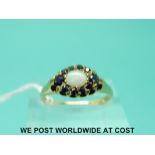 A 9ct gold ring set with an opal surrounded by sapphires (size N)