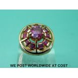 An 18ct gold ring set with pink sapphires in a circular setting with textured surround (size P)