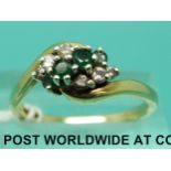 A 9ct gold ring set with three emeralds and six diamonds in a twist setting (size P)