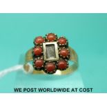 A Victorian ring with a glass compartment to the centre with plaited hair surrounded by coral