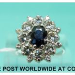 An 18ct white gold ring set with a sapphire surrounded by diamonds,