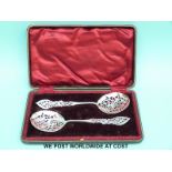 A cased pair of Edward VII hallmarked silver pierced and engraved sifter / serving spoons,