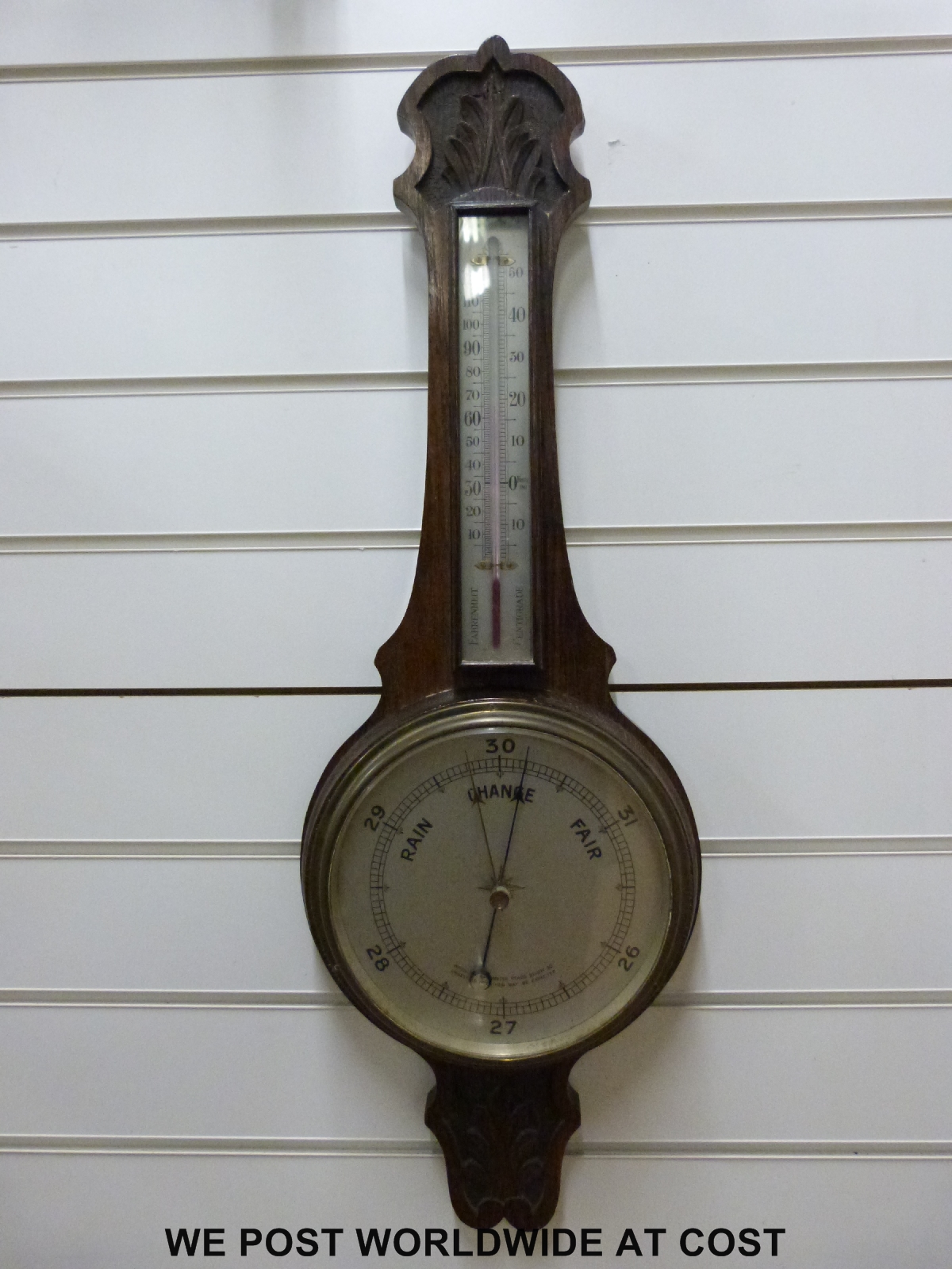 An early 20thC oak cased banjo barometer with carved decoration and thermometer,