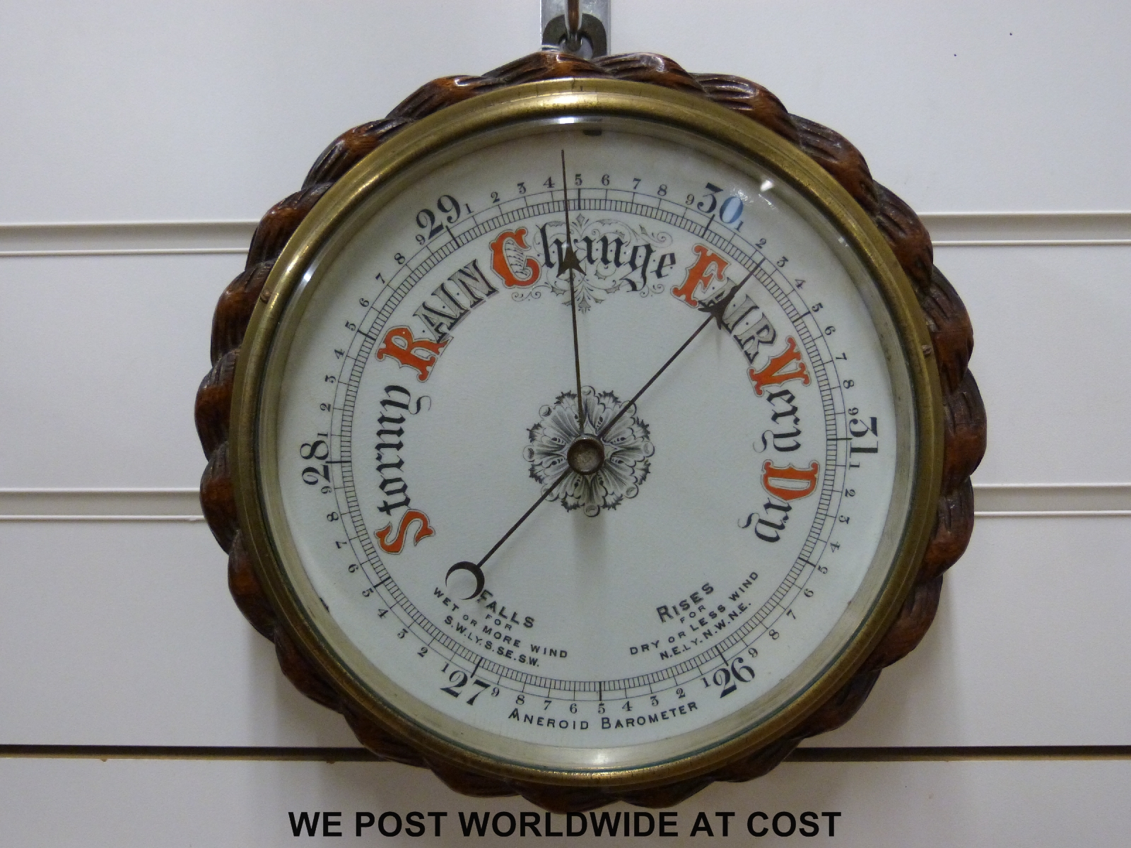 A brass and wooden cased aneroid barometer (20cm diameter dial)