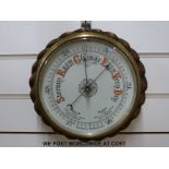 A brass and wooden cased aneroid barometer (20cm diameter dial)