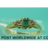 An 18ct gold ring set with a a square emerald and two diamonds (size K)