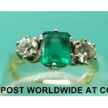 An 18ct gold ring set with an emerald cut emerald of approximately 1ct and a diamond to each side