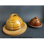 A Winchcombe Pottery cheese board with a dome and another smaller example