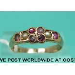 An Edwardian 9ct gold ring set with seed pearls and rubies (size O)