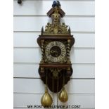 A continental wall clock with brass figural decoration and two large brass weights,