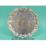 A George IV hallmarked silver salver with decorative rim raised on three scrolling feet,