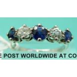 A white metal ring set with three sapphires and two diamonds (size M)