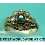 A yellow metal Victorian ring set with an emerald surrounded by rose cut diamonds (size M)