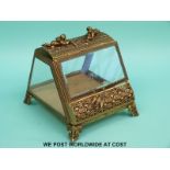 A gilt metal and bevelled glass table top bijouterie cabinet with cherubs to top (W14xD16xH14.