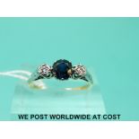 An 18ct gold ring set with a sapphire flanked by diamonds in a platinum setting (size N)