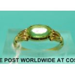 A yellow metal ring set with an oval peridot (size I)