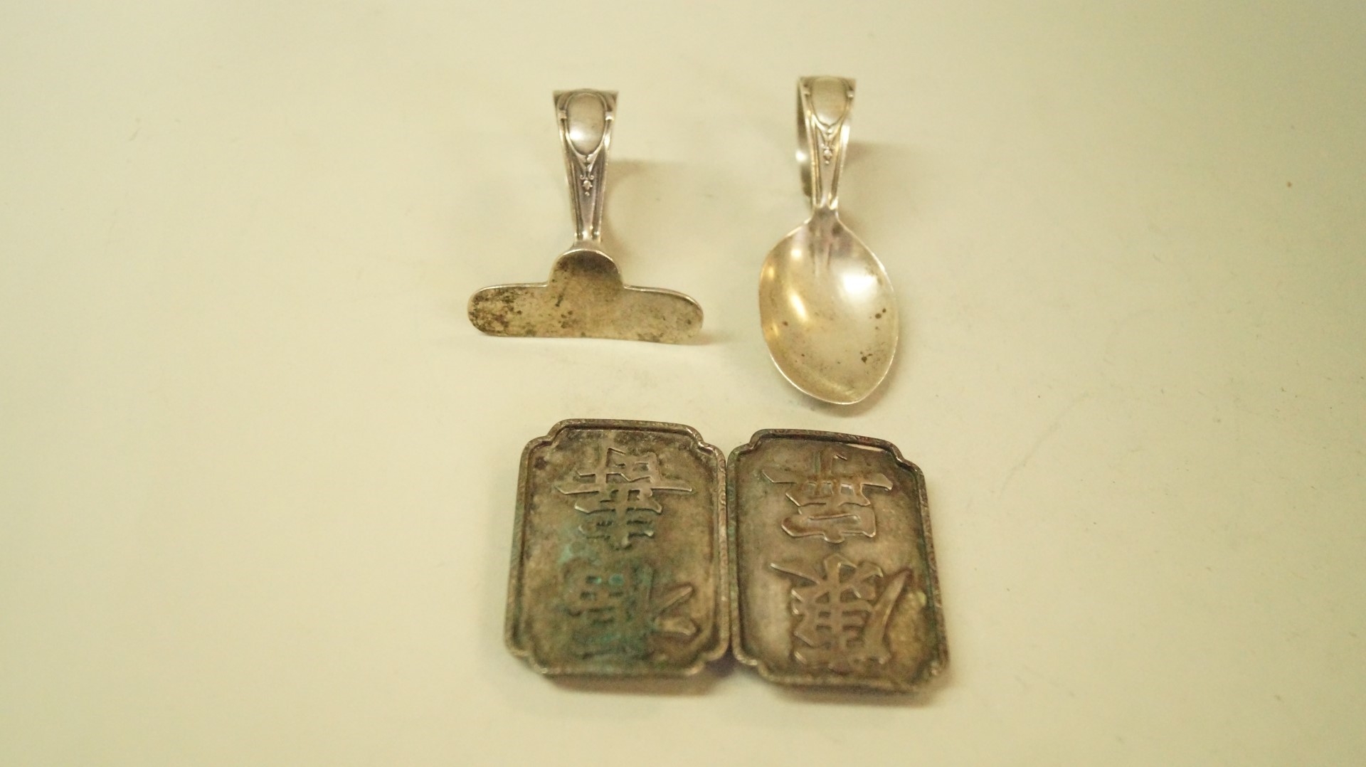 A Chinese silver plated belt buckle; together with a silver babies spoon and pusher,