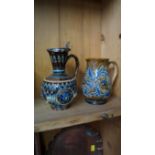 Two Doulton Lambeth stoneware jugs, one with electroplate hinged cover, largest 18cm high.