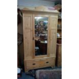 An antique pine wardrobe, with mirrored door, 125cm wide.