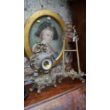 A rococo style cast brass easel, 53cm high; together with another rococo style timepiece.