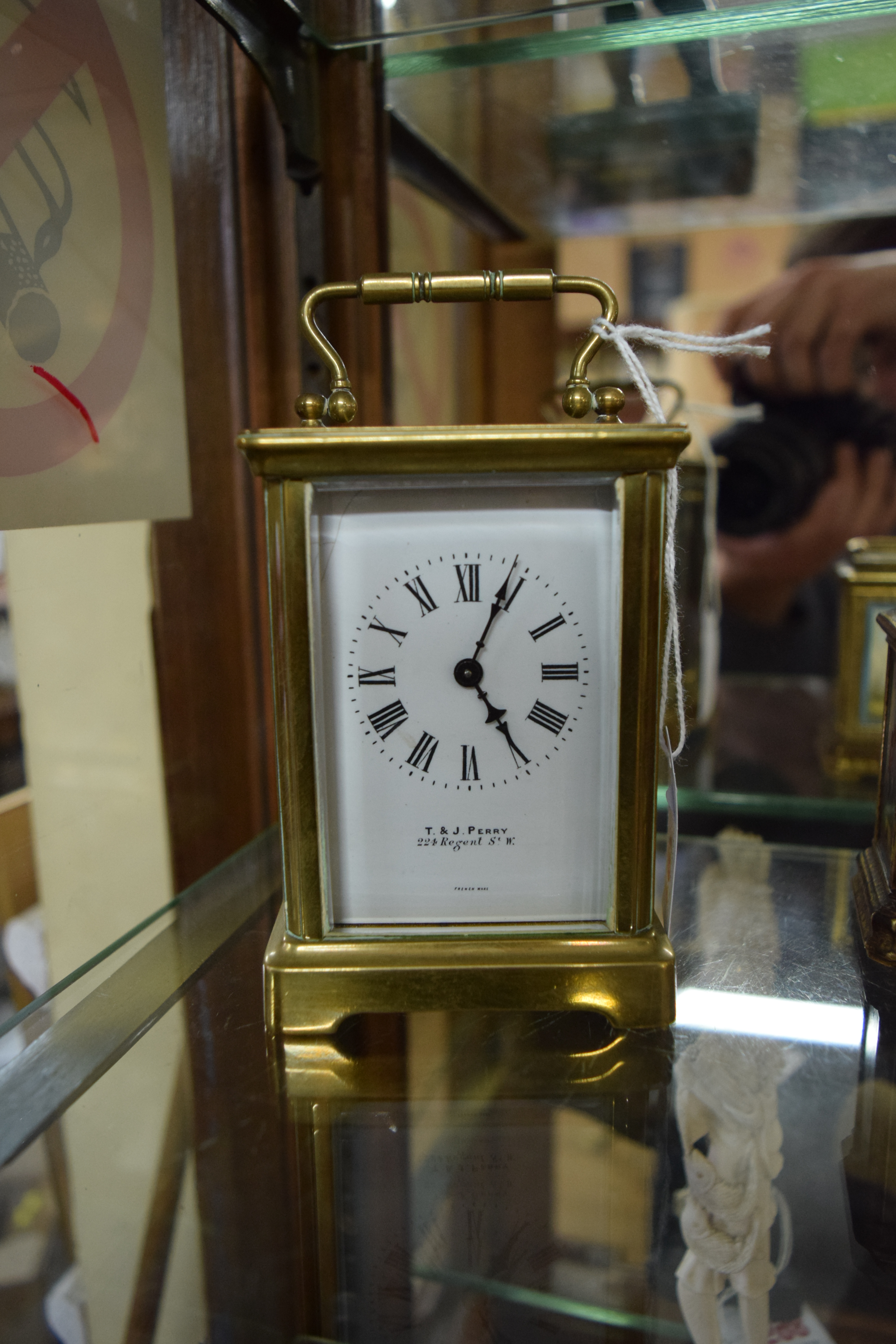 An old brass carriage timepiece, the enamel dial inscribed 'T & J Perry, 224 Regent St, W.