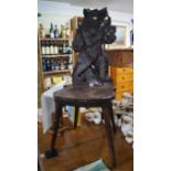 A late 19th/early 20th century Black Forest carved wood hall chair,