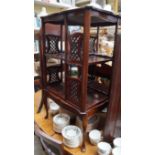 A late Victorian mahogany revolving bookcase, the shaped top with silver presentation plaque,