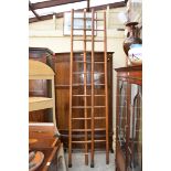 Two antique oak and beech thirteen rung ladders, each approx 275cm long.