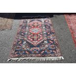 A geometric rug, having three central medallions, blue bordered,