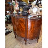 A 1920s mahogany side cabinet, of bowed serpentine form, 114cm wide.