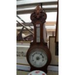 A late Victorian carved oak aneroid wheel barometer.