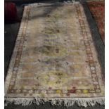 A Turkish rug, having pastel colour with eight central medallions, 216 x 129cm.